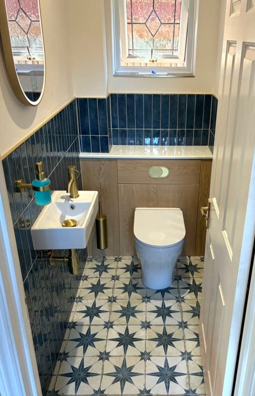 Small separate toilet with a wall hung basin, gold tapware and back to wall pan